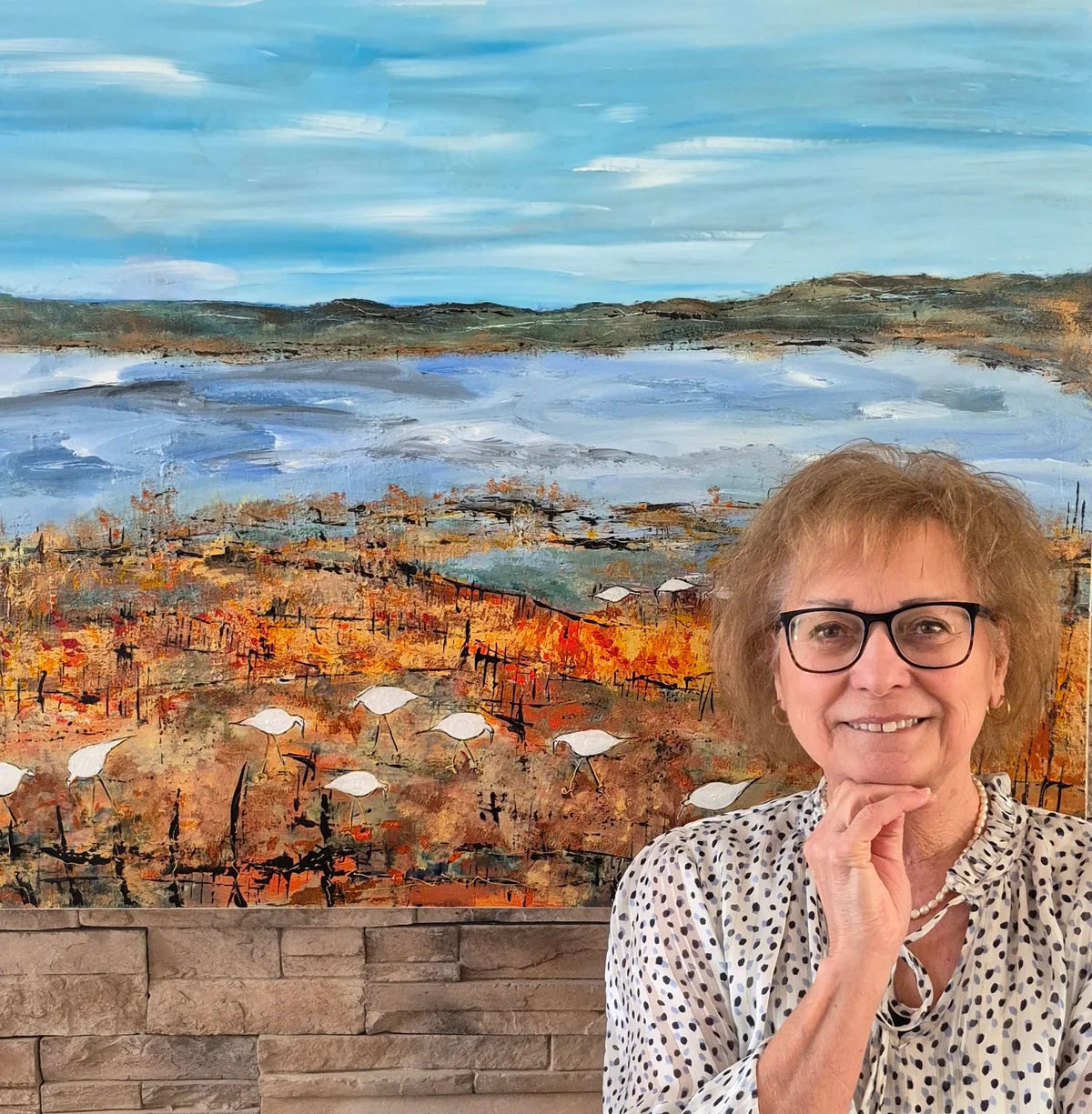 Ghislaine Riendeau devant sa toile Dans les herbes Hautes.